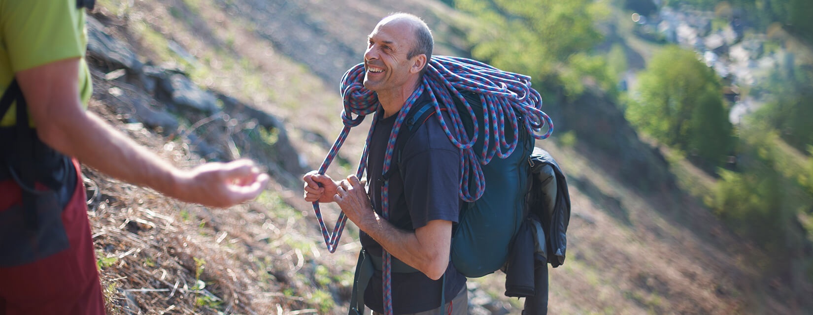 Man mountain climbing, holding a rope