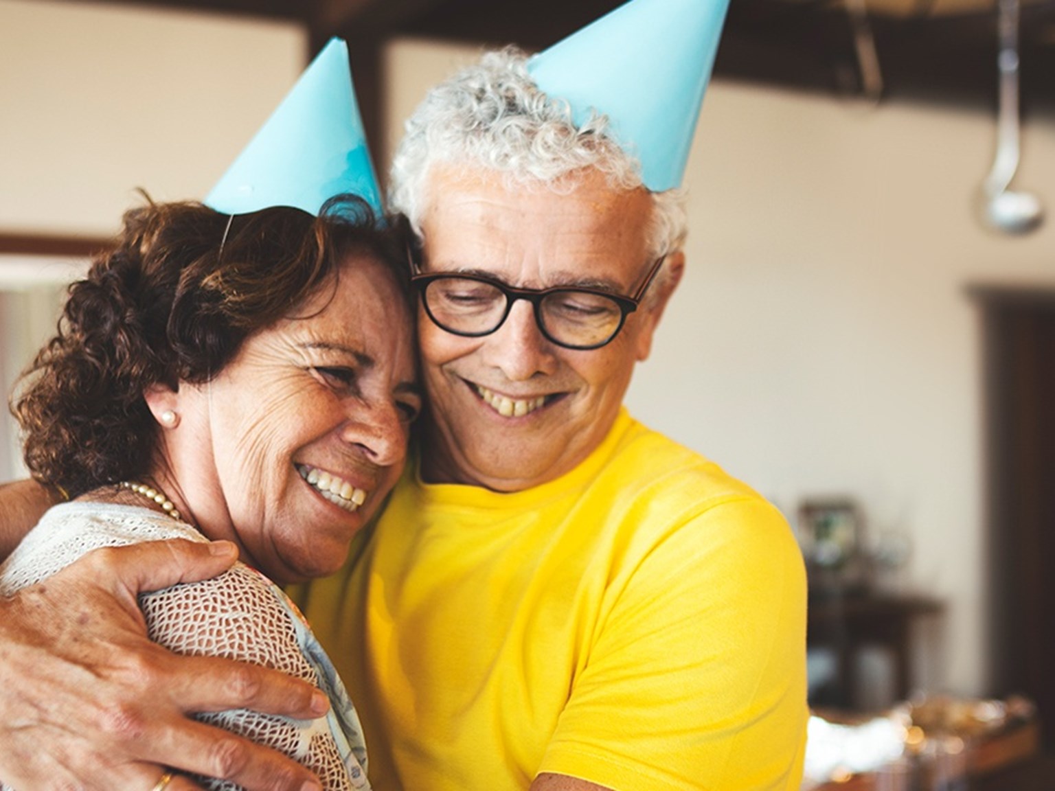 Couple hugging and smiling while wearing party hats