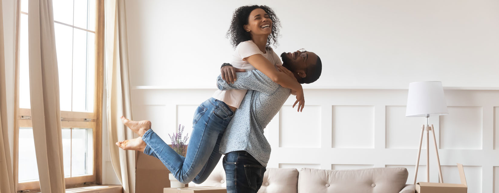 Man lifting woman in his arms, both laughing