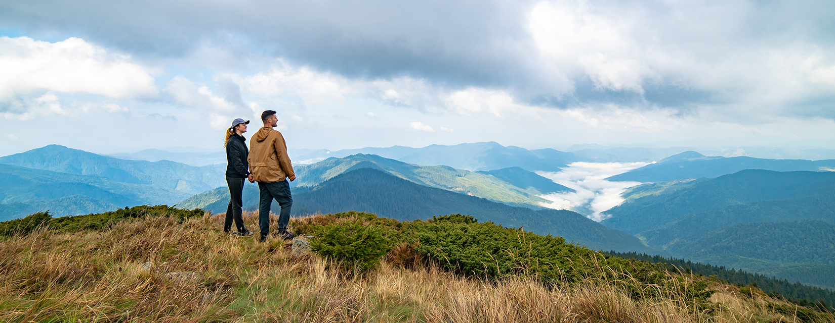 Couple looking at the view on the top of a mountain