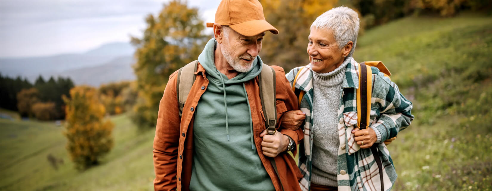 Older couple walking through a field