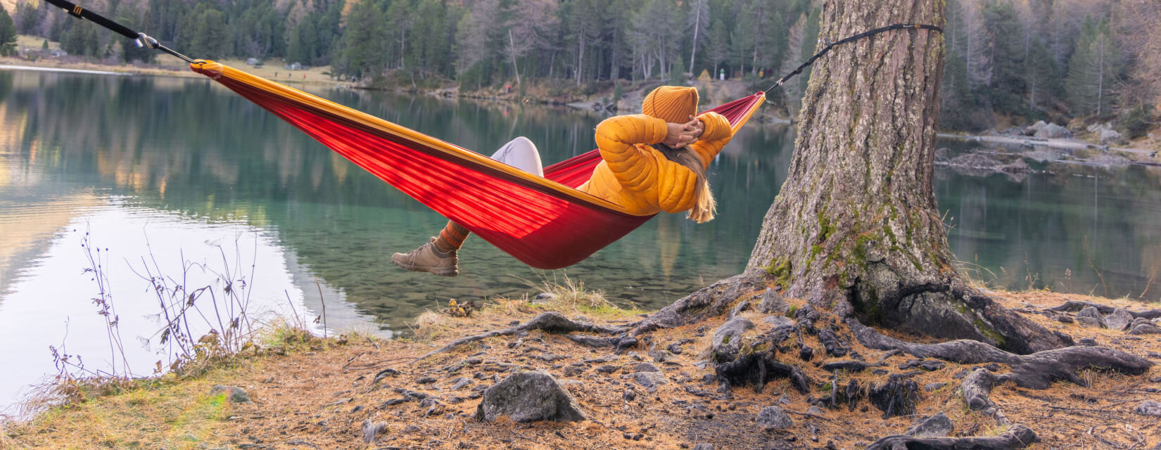 Woman laying in a hammock overlooking a lake