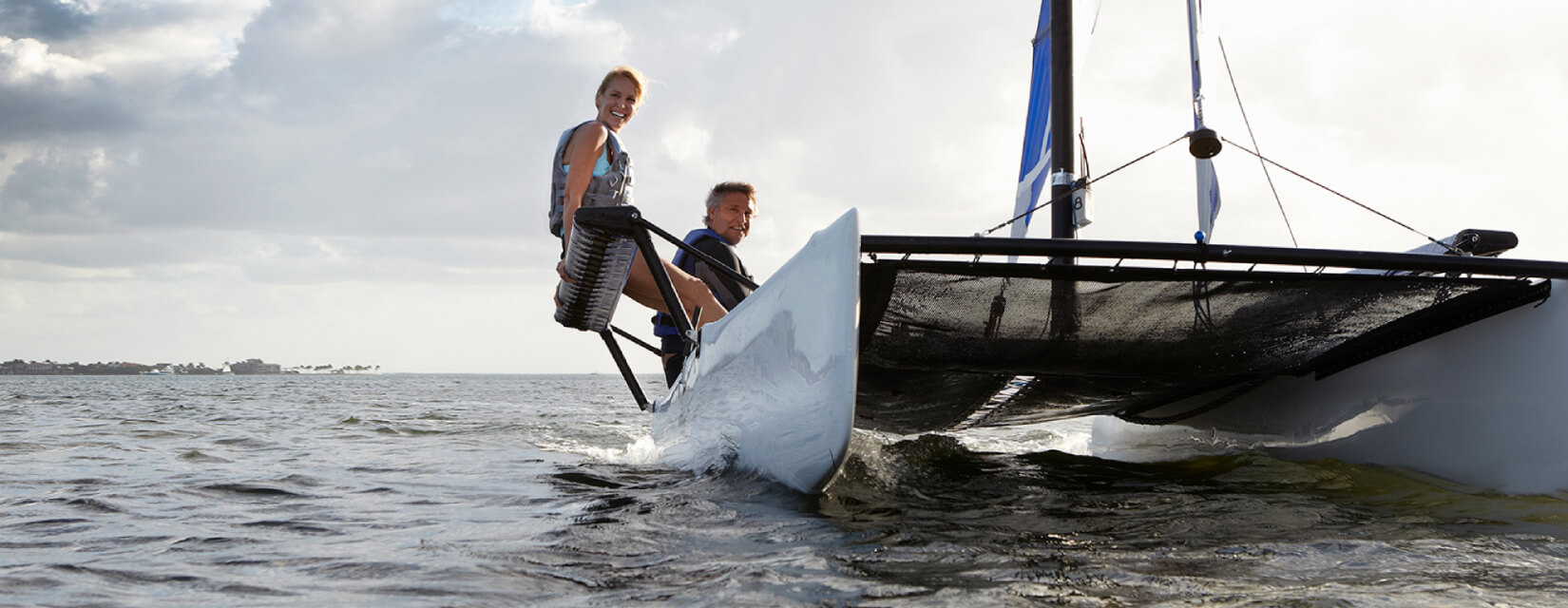 Couple sailing on a catamaran on a cloudy day 