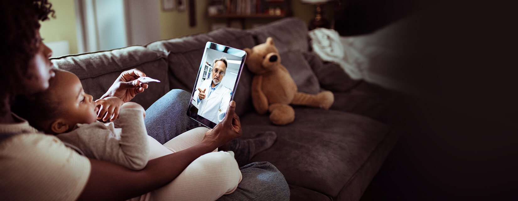 child looking at the ipad and mother looking at thermometer