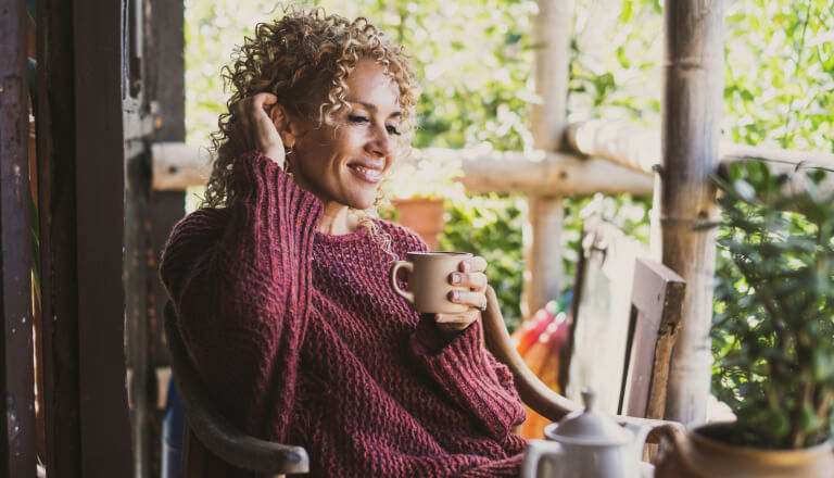 lady-relaxing-cup-porch-768x440