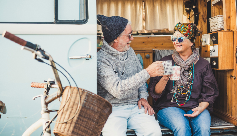 Mature couple having  a cuppa in a camper van