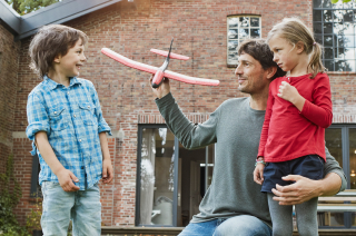 Family playing with a toy plane in the garden