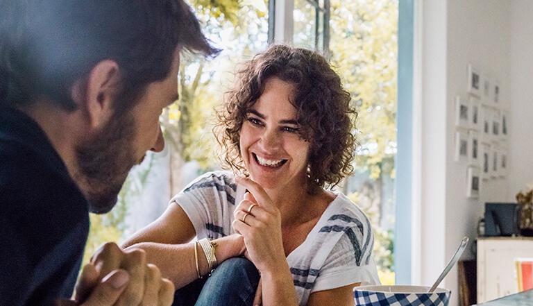 Man and woman sat across a table laughing