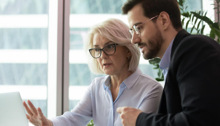 Woman and man discussing somehitng whilst both looking at a screen