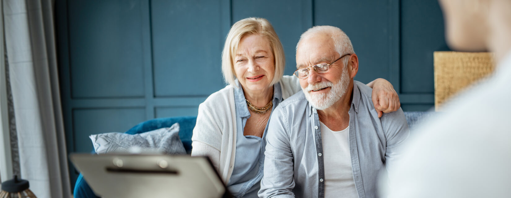 Older couple happily looking at a laptop