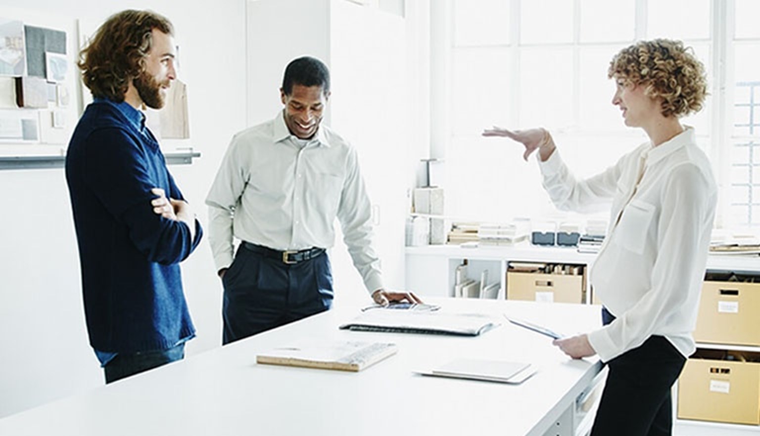 Three people in an office meeting
