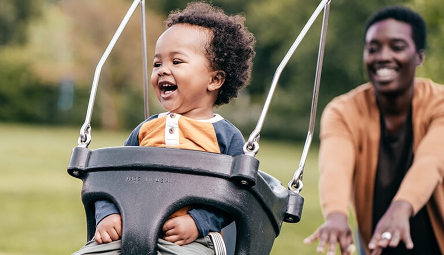 mother with baby in the swing at the park