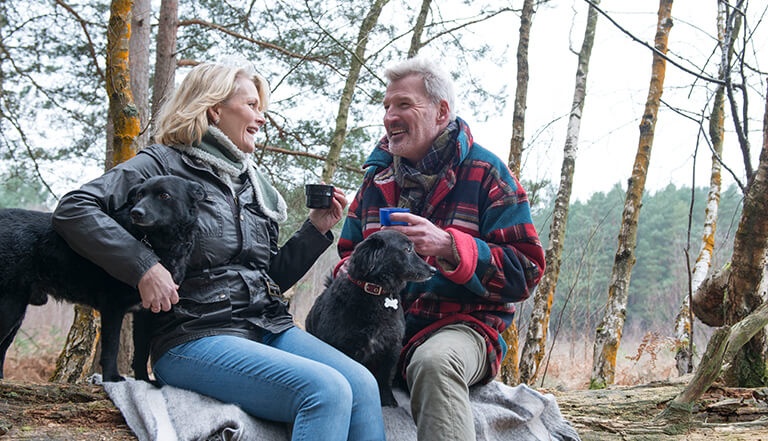 family on beach with young girl dancing and woman laughing