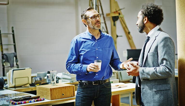 Two men talking while drinking coffee