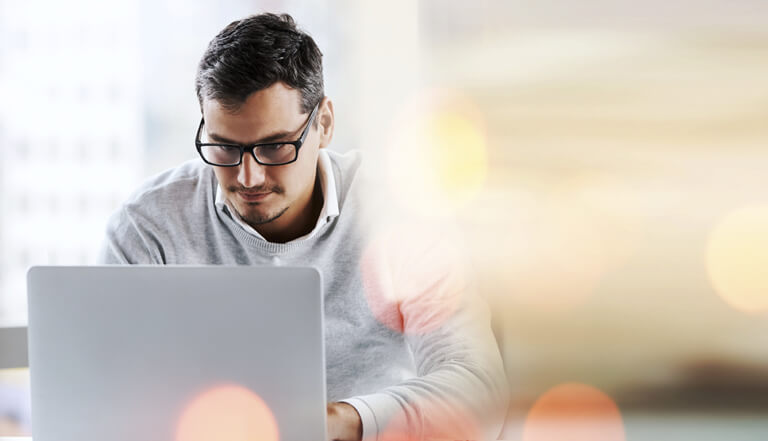Young professional working on a laptop with abstract light effect