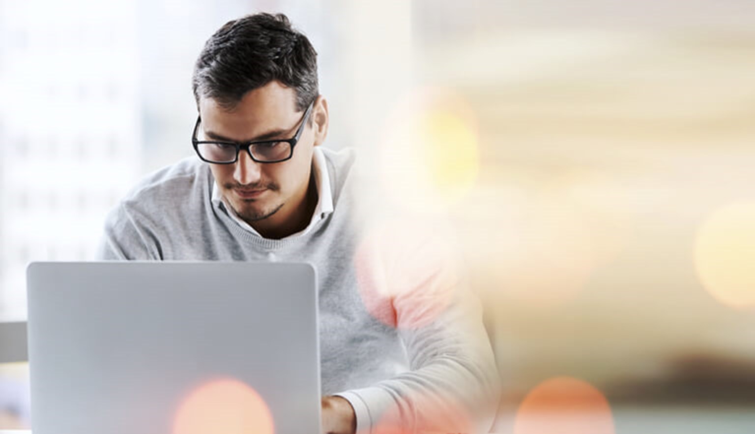 Young professional working on a laptop with abstract light effect