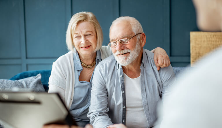 Older couple happily looking at a laptop