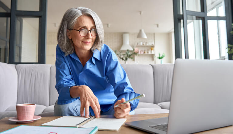 Woman sat on her sofa working on a laptop
